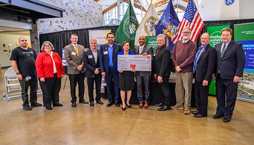 A picture of 11 people representing Global Foundries and 哈德逊山谷社区学院. The two people in the center hold a large check to represent the donation.